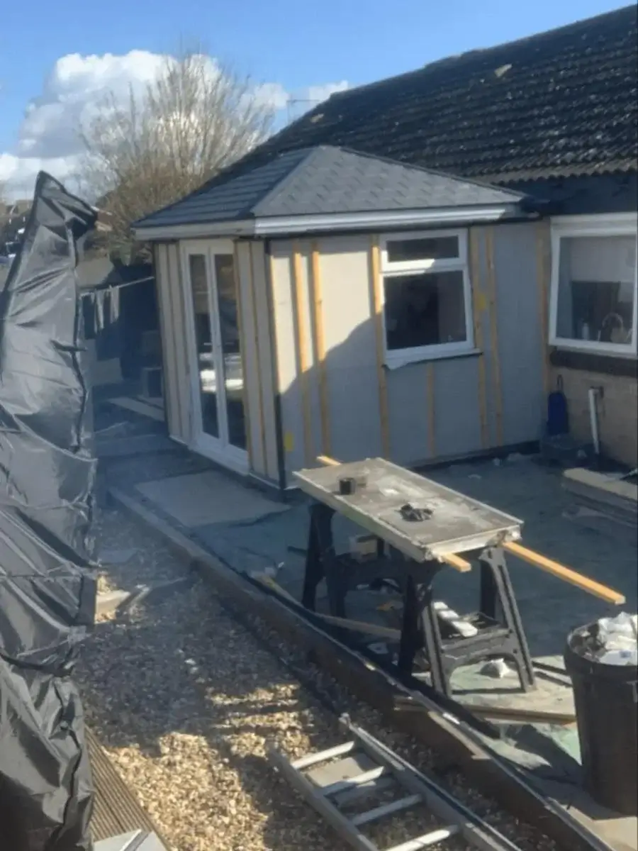 Progress shot showing the insulated wall panels and pitched roof trusses assembled on a patio site. Built by Norfolk Exterior Solutions